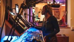 a woman with braids uses DJ decks
