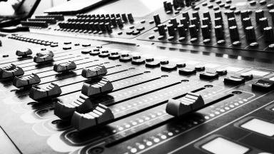 Black and white photo of music mixer board.