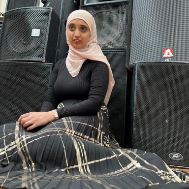 a person wears a pink hijabi and black long sleeve top with a flowy skirt