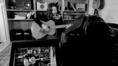 camera recording a person playing guitar