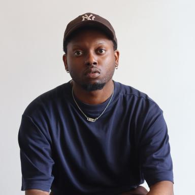 Nicolas-Tyrell wears a navy t-shirt and black baseball cap