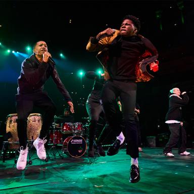 two artists jump on stage with a microphone in their hands