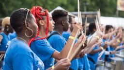 young musicians wearing blue tshirts drumming