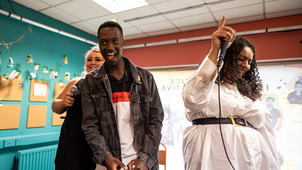 a group of young people laugh and smile as they make music