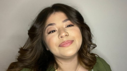 a woman with dark brown wavy hair smiles at the camera