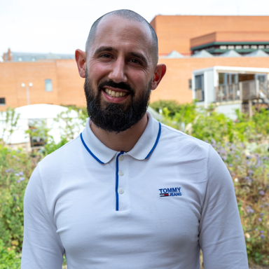 a man with a bears and shaved head smiles