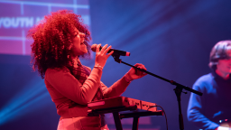 a woman sings passionately into a microphone