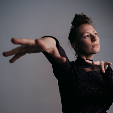 a woman wears a long sleeve black top and holds her hands towards the camera