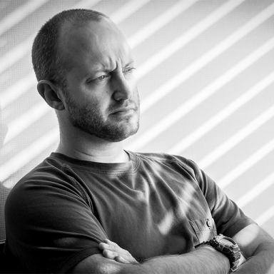 black and white photo man standing with arms crossed 