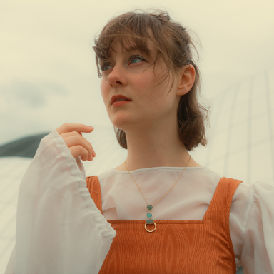 a woman with short brown hair looks into the distance