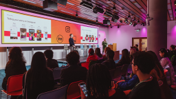 two people present to a room full of people sitting on chairs