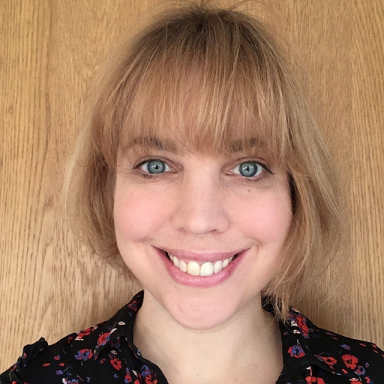 a woman with blonde short hair and a fringe smiles