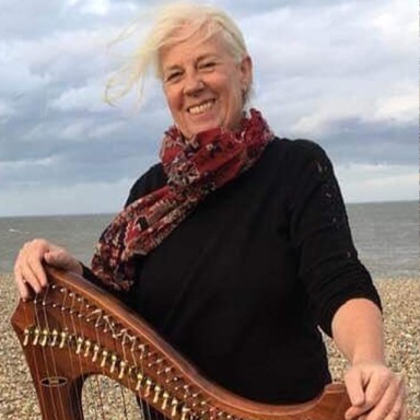 xenia poses on the beach with a harp